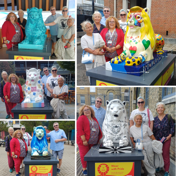 Carers visiting colourful Portsmouth lion sculptures, posing beside five uniquely decorated lions on the Lion Hunt trail.