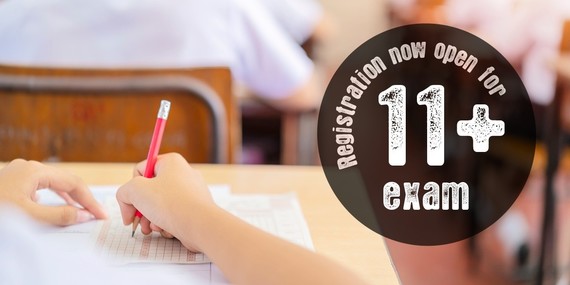 Boy sat at a desk holding a pencil