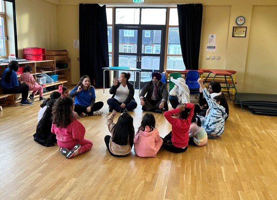 Cllr Athwal sitting with children