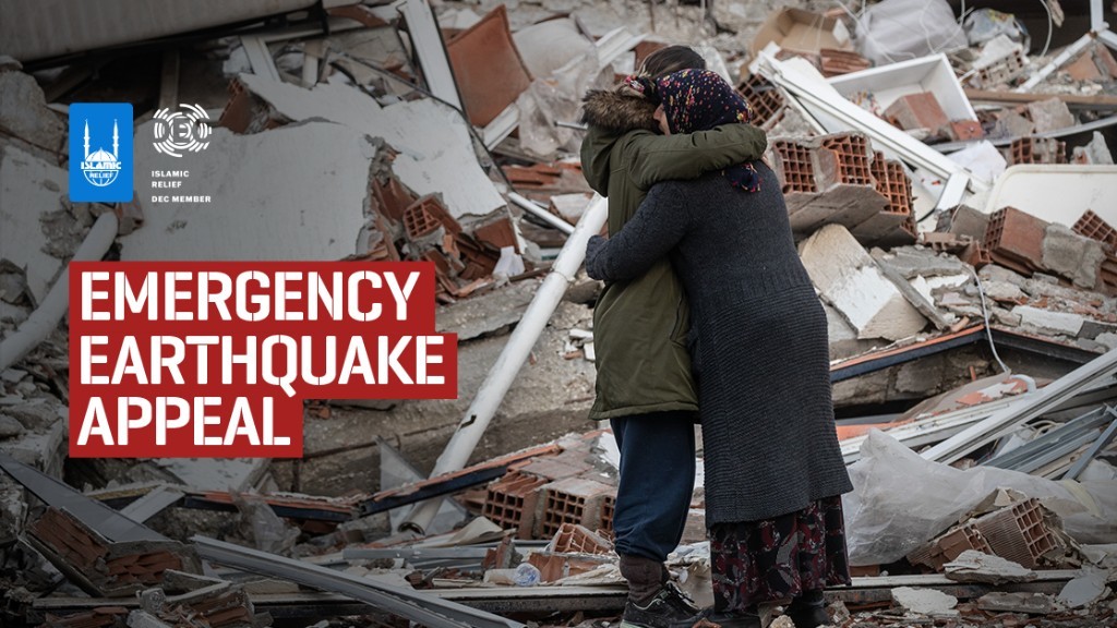 Earthquake survivors hugging with rubble in background