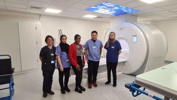 Clinical staff stood beside MRI scanner
