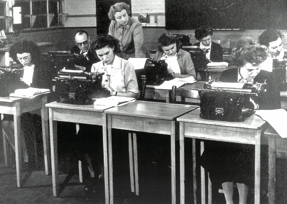 Black and white image of women on typewriters