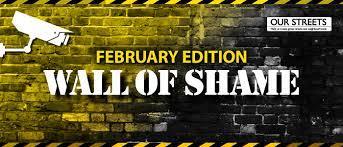 Image of brick wall with text saying wall of shame