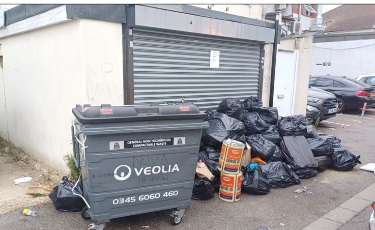 Wheelie bin next to rubbish sacks