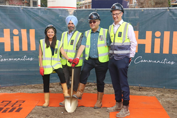 Councillors in high-visibility clothing holding shovel
