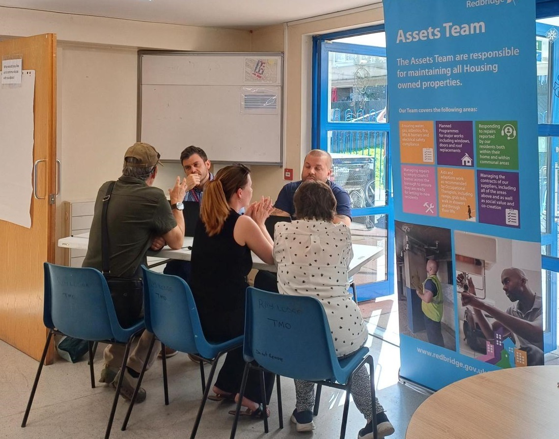 Three residents are talking to two officers from the housing asset management team