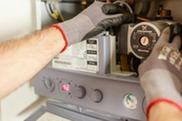 a hand reaching into a gas meter to carry out checks