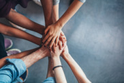 Men and women putting hands together - unity - support network