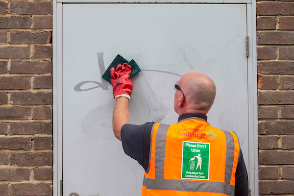 Street cleaner removing graffiti from a door