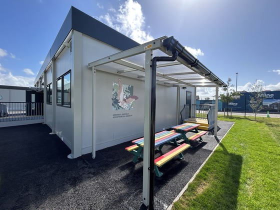 Outside of modular unit showing artwork and rainbow coloured bench