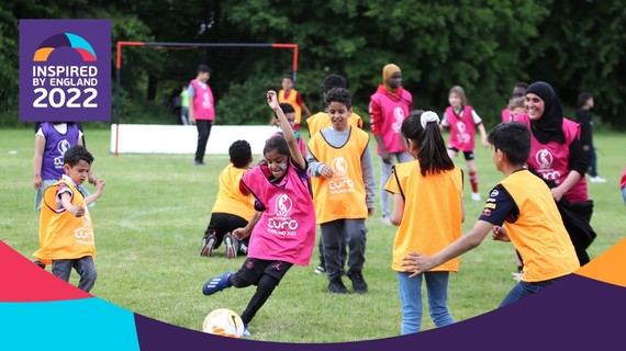 Young girl dribbles through crowd of players on park.
