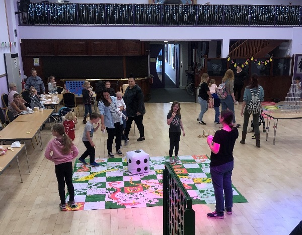 Families playing floor and table top games inside Lyric theater