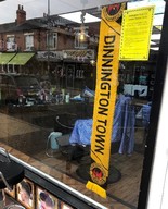 barbers shop window displaying football scarf