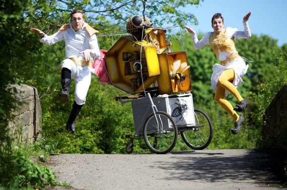 Man and woman dressed as bees, with handmade whacky cart.