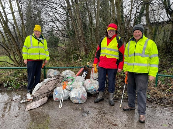 people stood next to a bin litter picking