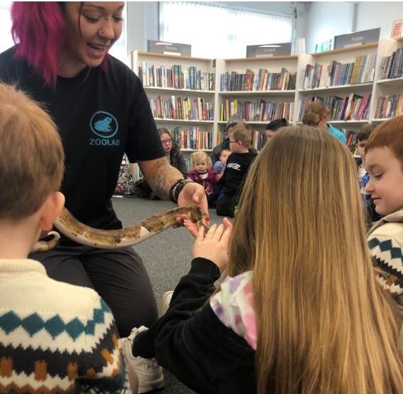woman showing snake to children