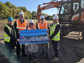 People stood in front of earth mover