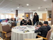A school group of young people getting involved with interactive activities with their table group and teachers.