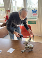 Glastonbury Repair Cafe - Man with Ornamental Silver Hare (Made of Spoons)