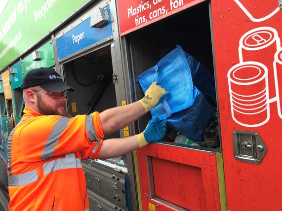 Recycling crew member putting waste in the truck