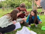Family observing insects with magnifying glass