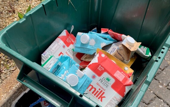 Recycling containers stacked at the kerbside with cartons inside