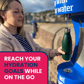 Person topping up a reusable water bottle on MInehead Sea Front