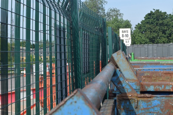 A line of  blue and green skips at a recycling site