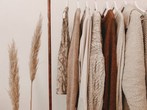 A rail of beige coloured clothing items hung from it