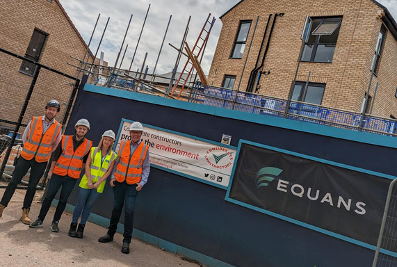 Group of Equans construction workers and a council officer standing in front of part of the newly constructed North Taunton Woolaway project.