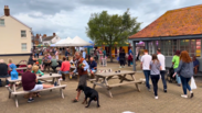 Streetscape of visitors relaxing at the market near the harbour in Watchet.