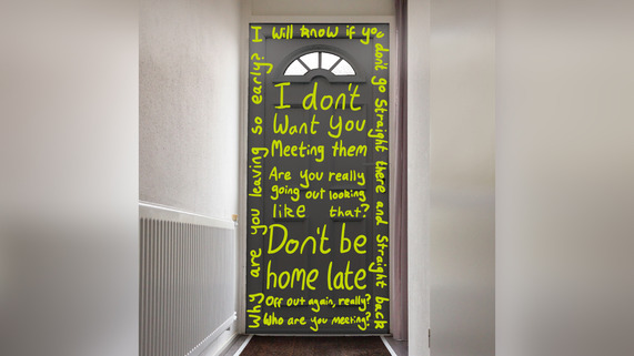 Inside of a front door with domestic abuse messages written on them.