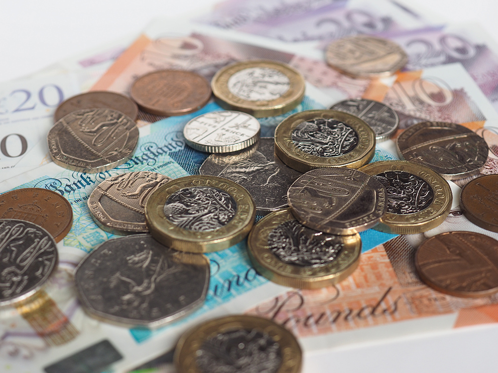 British coins and bank notes stacked.