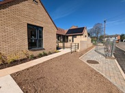 Wheelchair-adapted homes with pitched roofs, solar panels and small gardens.