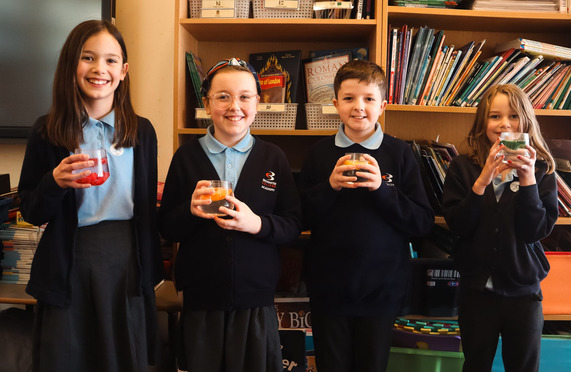 Year 6 pupils holding glasses of water.