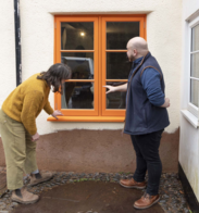 Two people looking at new windows on a cottage