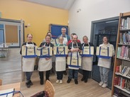 Group of Westfield Local Pantry volunteers each holding a hessian bag displaying Westfield Local Pantry's logo.