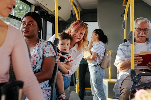 multi-generational people onboard a bus with young mum and child smiling