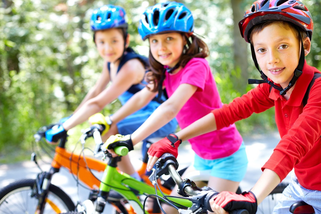 three children on their bikes wearing helmets