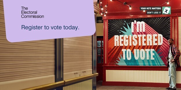 Social graphic featuring a black man beside an internal market stall with a closed shutter, captioned: 'I'm registered to vote'.