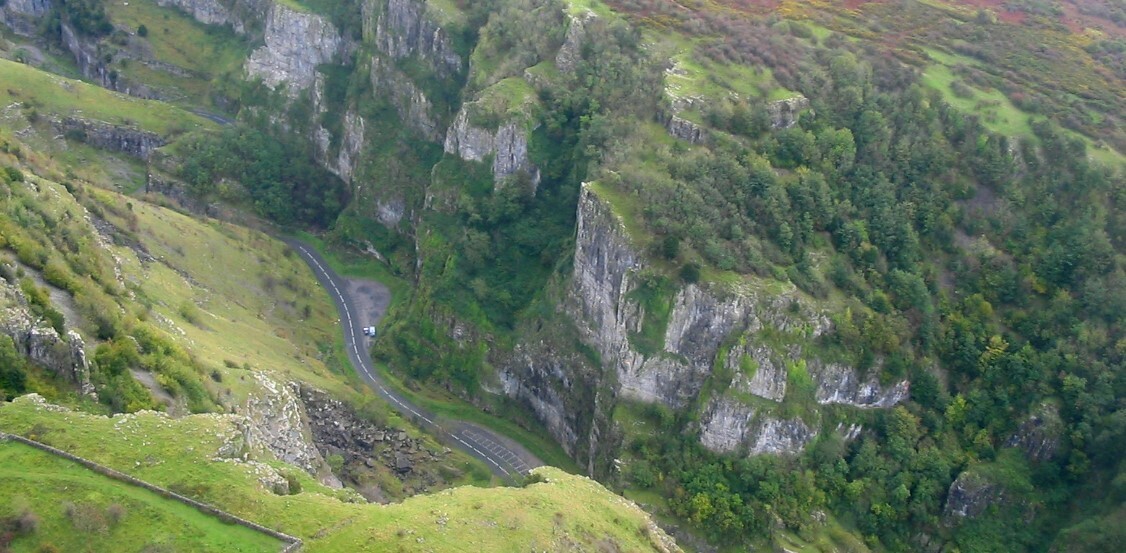 View of Cheddar Gorge from above which shows the road running through it.