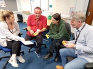 People sitting around a table during a naloxone training session.