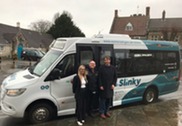 Cllr Richard Wilkins with Digital Slinky staff members standing in front of the minibus.