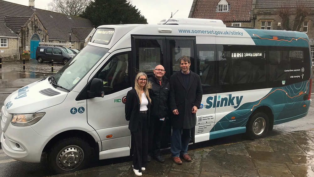 Cllr Richard Wilkins with Digital Slinky staff members standing in front of the minibus.