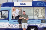 Photograph of customer enjoying an ice cream outside of an ice cream van.