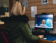 Person sat in front of a computer screen on a video call with another person.