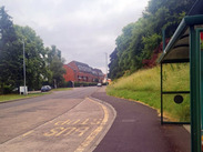 4x3 stretch of Hendford road in Yeovil, featuring a bus stop and houses in the distance.