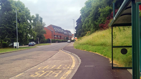 A stretch of Hendford in Yeovil, featuring a bus stop and houses in the distance.