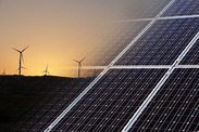 Solar panels with wind turbines in background.