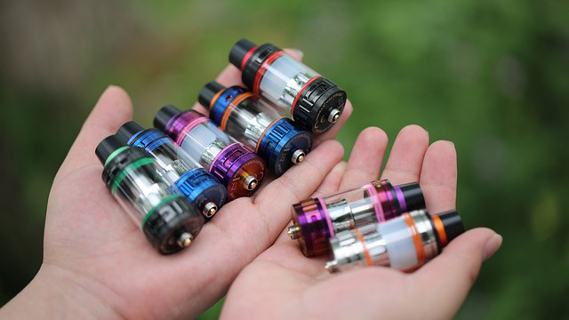 Stock image of hands offering a range of vaping tanks by haiberliu from Pixabay.